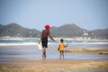 African woman and child walking on the beach Royalty Free Stock Photo